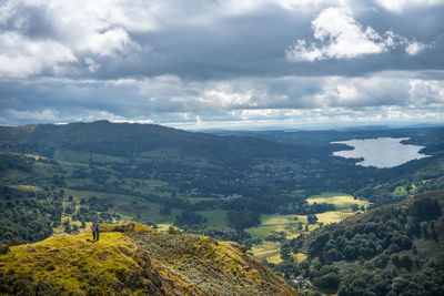 Rear view of man standing on landscape against sky