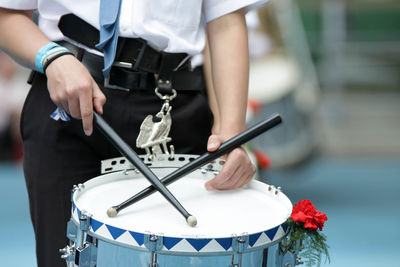 Midsection of man playing drum at music concert