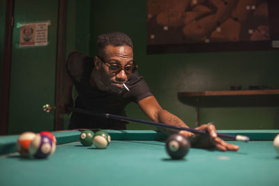 A young man playing pool.