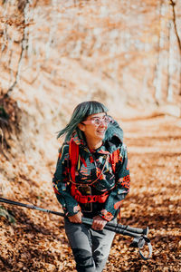 Side view of young woman standing in forest