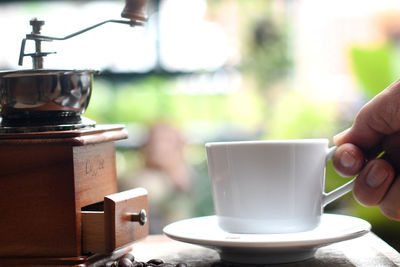 Close-up of hand holding coffee cup