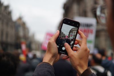 Midsection of person photographing with mobile phone