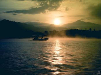 Boat sailing in lake during sunset