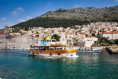 Scenic view of sea by townscape against sky