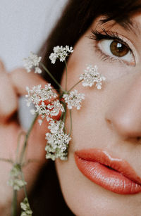 Close-up of woman with pink flower