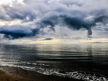 Scenic view of sea against storm clouds