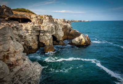 Rocks on sea shore against sky