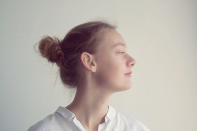 Portrait of young woman against white background