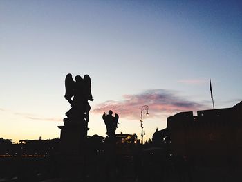 Silhouette of building against sky at dusk