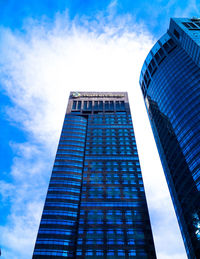 Low angle view of modern building against cloudy sky