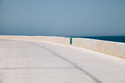 View of road by sea against sky