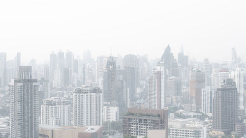 Aerial view of buildings in city against sky