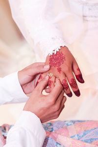 Midsection of newlywed couple holding hands