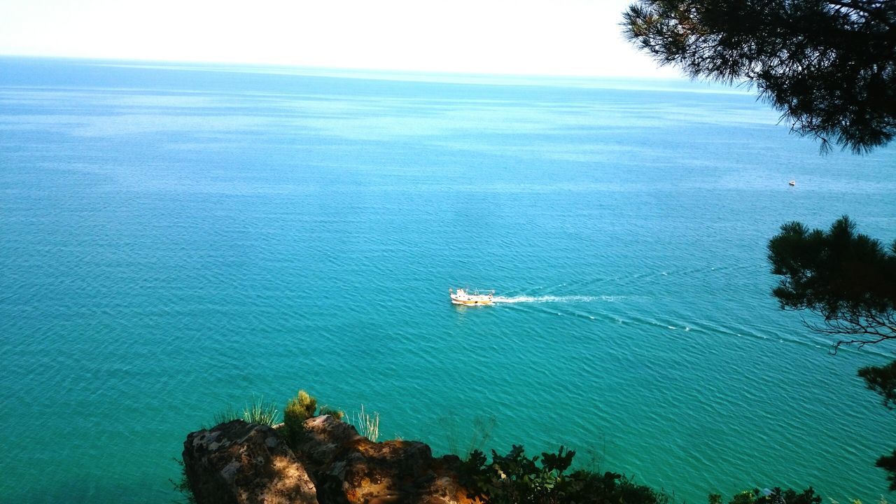 water, sea, tranquil scene, scenics, tranquility, nautical vessel, transportation, tree, beauty in nature, blue, mode of transport, horizon over water, nature, boat, sky, high angle view, idyllic, travel, waterfront, day