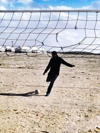 Man playing soccer on beach