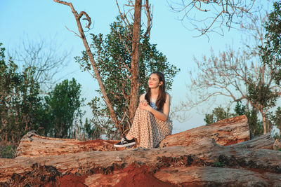 Woman standing by tree against sky