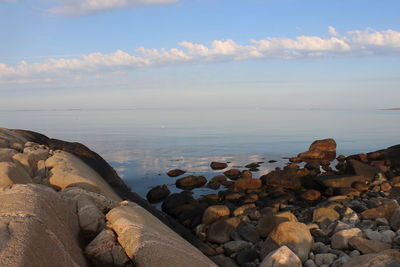 Rocks by sea against sky