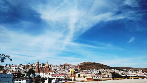 View of cityscape against blue sky