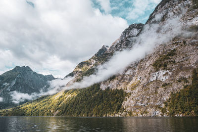 Scenic view of lake by snowcapped mountains against sky