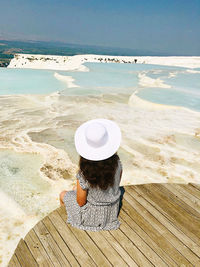 Girl in hat sitting near natural spa