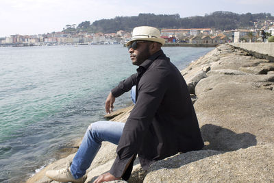 Black pensive man looking out to sea