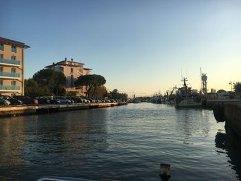 Scenic view of river by buildings against clear sky