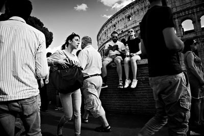 Rear view of people standing against sky