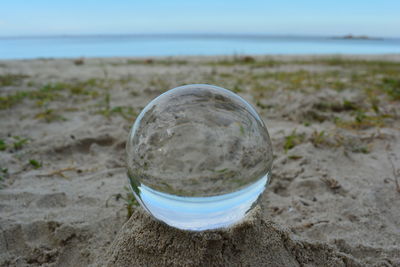 Close-up of crystal ball on beach