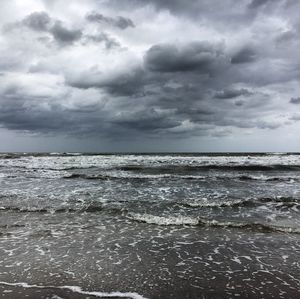 Scenic view of sea against storm clouds