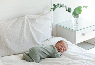Newborn baby sleeping on bed at home