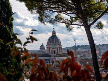 Panoramic view of buildings and trees against sky