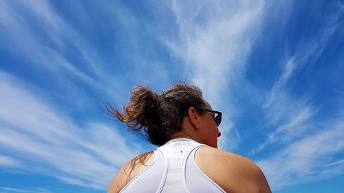 Low angle view of woman against blue sky