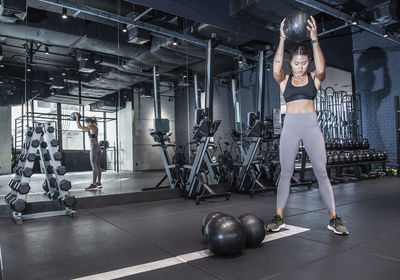 Woman working out with slamball in urban gym in bangkok