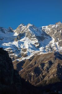 Scenic view of snowcapped mountains against clear blue sky