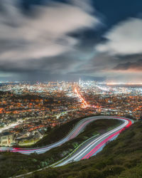 High angle view of illuminated city against sky at night