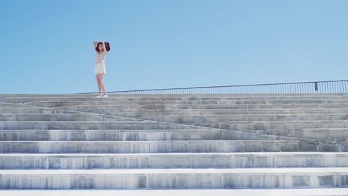 Full length of woman standing on steps