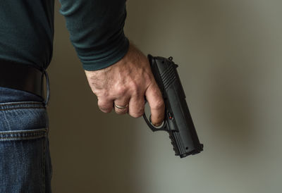 Midsection of man holding camera at home