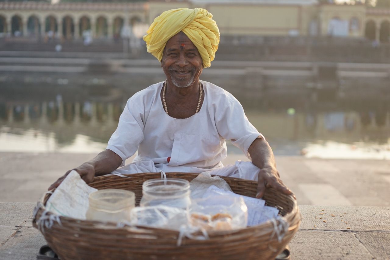 lifestyles, focus on foreground, leisure activity, casual clothing, person, holding, front view, standing, incidental people, looking at camera, sitting, food and drink, smiling, portrait, waist up, day, outdoors, water