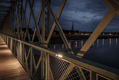 Bridge over river against sky at night