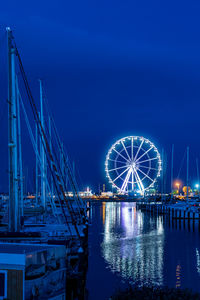 Illuminated ferris wheel against sky at night