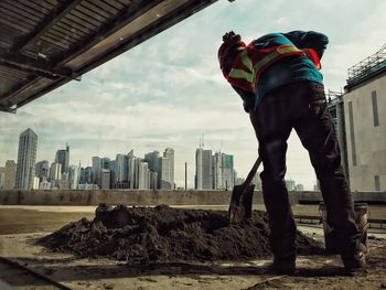 Rear view of man standing by modern buildings in city