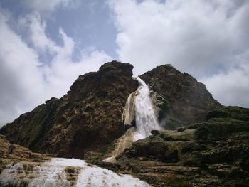 Low angle view of waterfall against sky