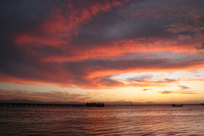 Scenic view of sea against dramatic sky during sunset