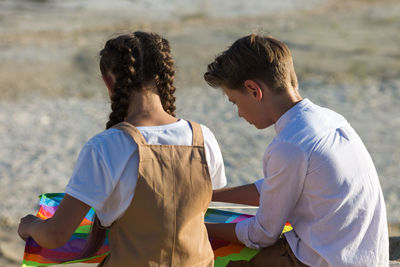 Children in nature playing with toys, view from the back.