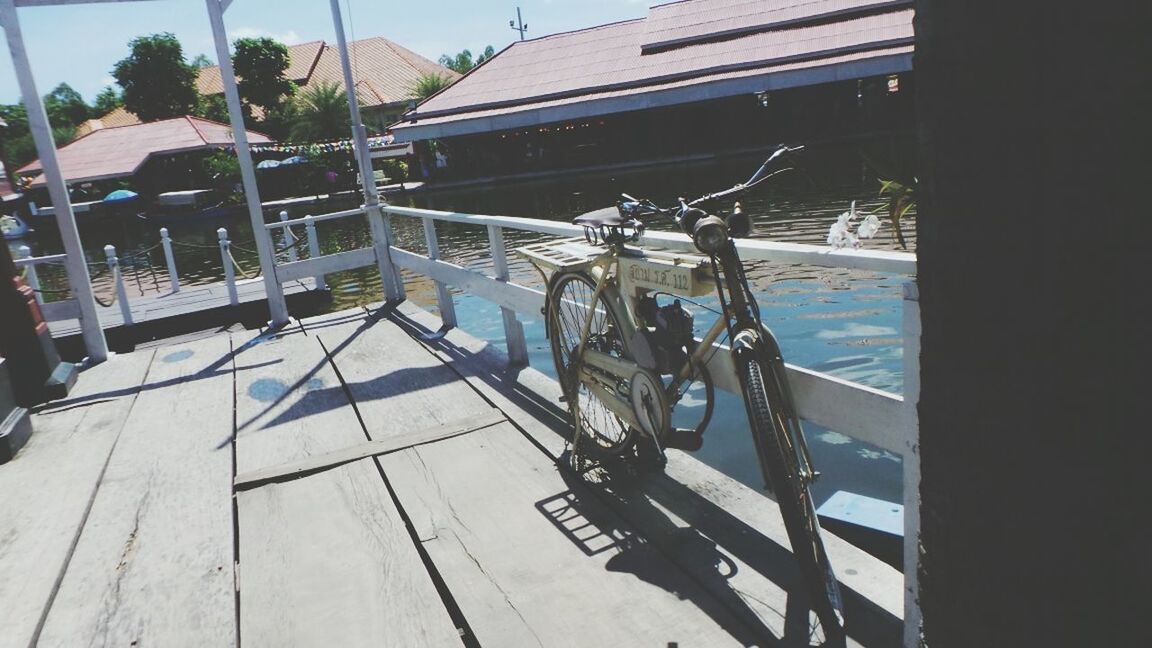 transportation, mode of transport, nautical vessel, boat, moored, water, sea, travel, day, sunlight, railing, incidental people, mast, built structure, outdoors, shadow, high angle view, bicycle, harbor, sky