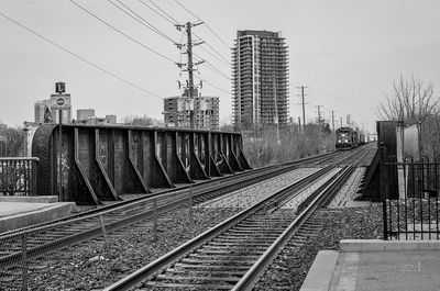 Railroad tracks in city against sky