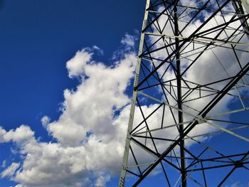 Low angle view of electricity pylon against blue sky