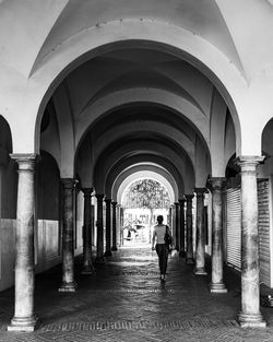 Rear view of man walking in corridor of building