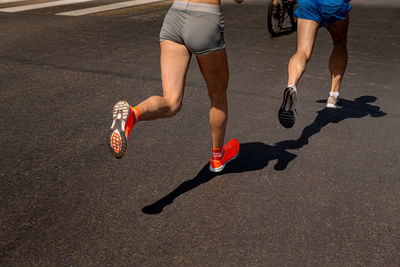 Low section of woman walking on road