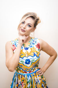 Portrait of smiling young woman standing against white background